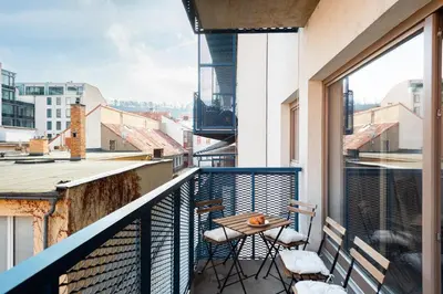 a bedroom with a bed with a large window at Spacious apartments near Karlín Square in Prague