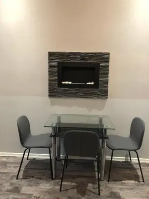 a dining room table with two chairs and a fireplace at Cozy Homestay at Prague Main Station in Prague