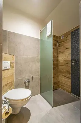 a bathroom with a toilet and a glass shower at Cozy Homestay at Prague Main Station in Prague