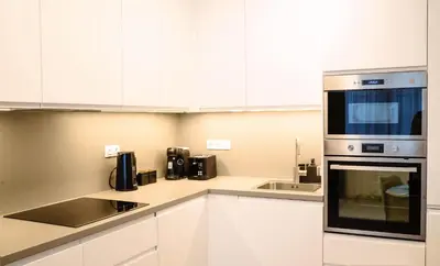 a kitchen with white cabinets and a microwave at Tran Chien Apartment with free private parking in Prague