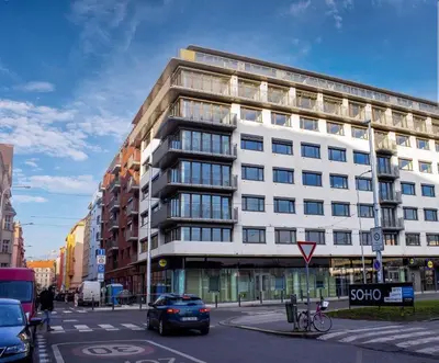 a large white building on a city street with a car at Tran Chien Apartment with free private parking in Prague