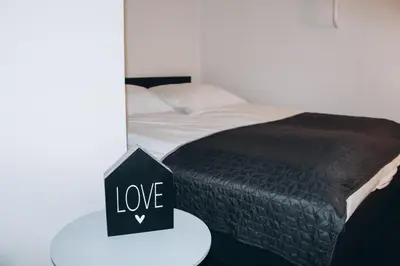 a bed with a table with a sign that says love at Sokolska in Prague