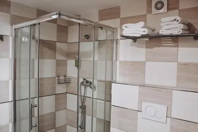 a bathroom with a shower with towels on a wall at Sokolska in Prague