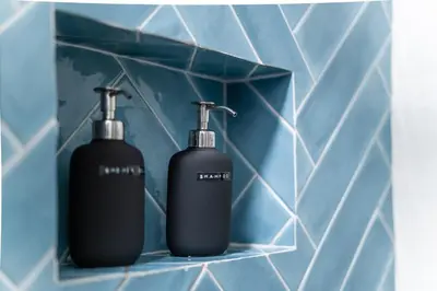 two black bottles sitting on a shelf in a bathroom at Malý byt s balkonem & free parking in Prague