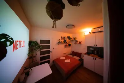 a small room with a bed and a kitchen at Malý byt s balkonem & free parking in Prague