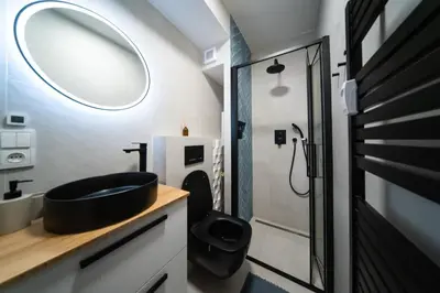 a bathroom with a black sink and a mirror at Malý byt s balkonem & free parking in Prague