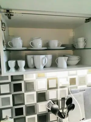 a shelf with plates and cups and dishes on it at 2 Bedrooms close Vyšehrad - Congress centrum in Prague