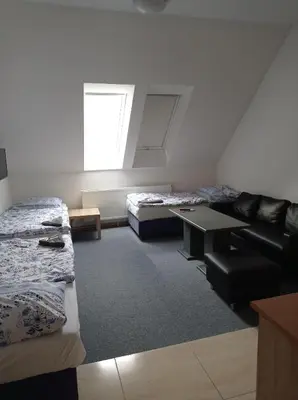 a room with two beds and a table in it at Penzion Pralinka in Rakovník