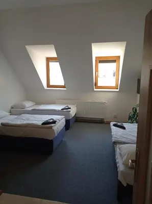 a room with three beds and two windows at Penzion Pralinka in Rakovník