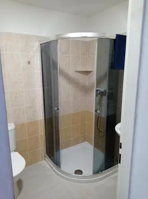 a shower with a glass door in a bathroom at Penzion Pralinka in Rakovník