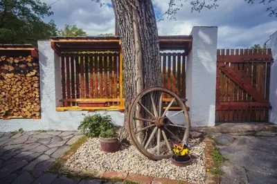 a woodenoked wheel sitting next to a tree with a fence at Chalupa Ořešák - Walnut House in Svojšice