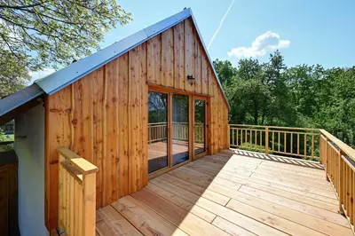 a large wooden cabin with a large deck at Chalupa Ořešák - Walnut House in Svojšice