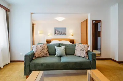 a living room with a green couch and a bed at U modrého orla - At the blue eagle in Prague