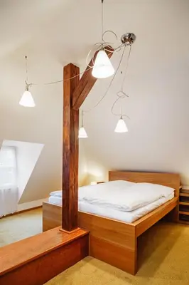 a bedroom with a wooden bed and two lights at U modrého orla - At the blue eagle in Prague