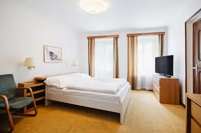 a bedroom with a bed and a tv and a chair at U modrého orla - At the blue eagle in Prague
