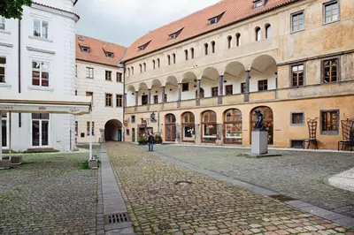 a cobblestone street in a city with buildings at U modrého orla - At the blue eagle in Prague