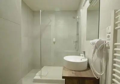 a white bathroom with a sink and a shower at Adeba Plus in Prague