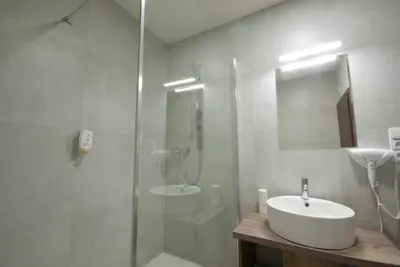 a white bathroom with a sink and a shower at Adeba Plus in Prague