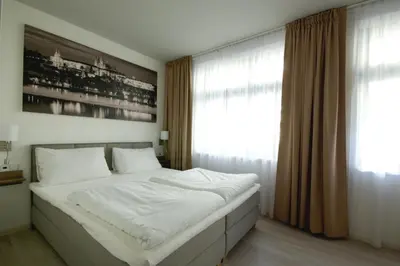 a bedroom with a large white bed in front of a window at Adeba Plus in Prague