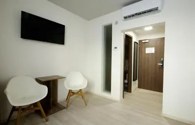 a living room with two white chairs and a flat screen tv at Adeba Plus in Prague
