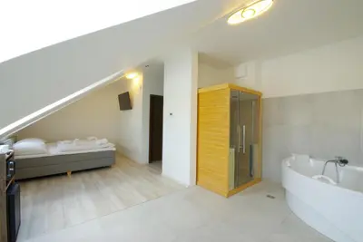 a bathroom with a bath tub and a sink and a staircase at Adeba Plus in Prague