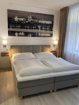 a bed in a bedroom with a picture on the wall at Adeba Plus in Prague