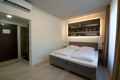 a bedroom with a bed and a painting on the wall at Adeba Plus in Prague