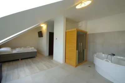 a bathroom with a bath tub and a sink and a staircase at Adeba Plus in Prague