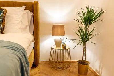 a bedroom with a bed with a lamp and a plant at Primavera - Castle view apartments in Prague