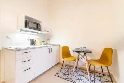 a kitchen with two chairs and a small table at Primavera - Castle view apartments in Prague