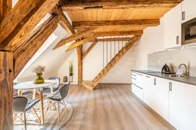 a kitchen with wooden ceilings and a table and chairs at Primavera - Castle view apartments in Prague