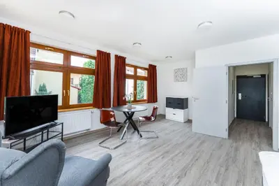 a living room with a tv and a table and chairs at Apartmán v Poděbradech in Poděbrady
