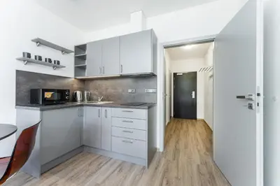 a kitchen with white cabinets and a counter top at Apartmán v Poděbradech in Poděbrady