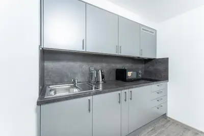a kitchen with white cabinets and a sink at Apartmán v Poděbradech in Poděbrady