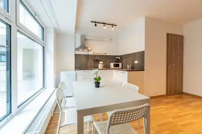 a kitchen and dining room with a white table and chairs at Brand new two room apartment #26 with free secure parking close to center in Prague