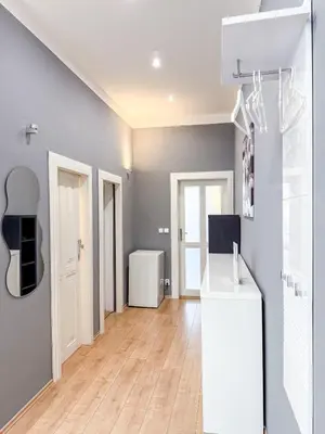 a kitchen with a white refrigerator and a wooden floor at Josefov Riverside Apartment in Prague