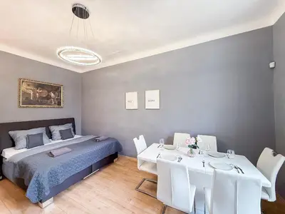 a bedroom with a bed and a table and chairs at Josefov Riverside Apartment in Prague