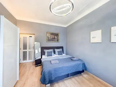 a bedroom with a bed with a blue blanket at Josefov Riverside Apartment in Prague