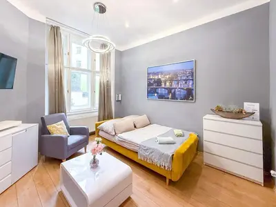 a living room with a bed and a chair at Josefov Riverside Apartment in Prague