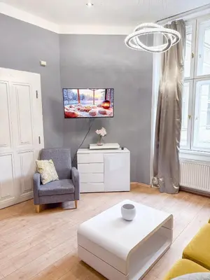 a living room with a couch a chair and a table at Josefov Riverside Apartment in Prague
