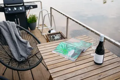 a bottle of wine sitting on a table with a glass at HOUSEBOAT FRED Prague in Prague