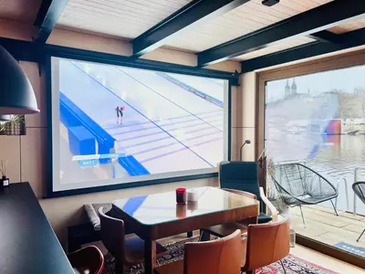 a large projection screen in a room with a table and chairs at HOUSEBOAT FRED Prague in Prague