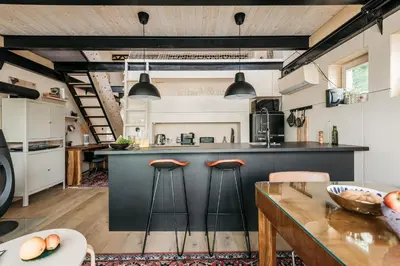 an open kitchen with a counter and stools at HOUSEBOAT FRED Prague in Prague