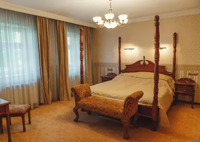 a bedroom with a canopy bed and a chair at hotel Memorial in Terezín