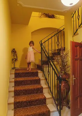 a little girl is walking down a set of stairs at hotel Memorial in Terezín