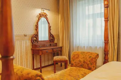 a bedroom with a mirror and a chair and a bed at hotel Memorial in Terezín