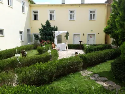 a garden in front of a white house at hotel Memorial in Terezín