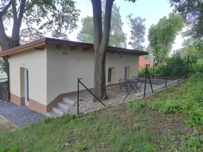 a small white building with a fence around it at Apartmán Višňová in Milovice