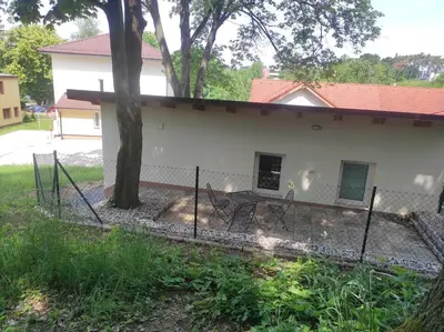 a fence in front of a white house at Apartmán Višňová in Milovice