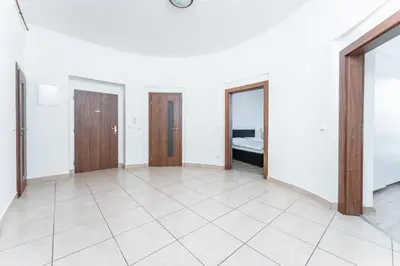 an empty room with two doors and a tile floor at Apartmán Riegrovo náměstí in Poděbrady